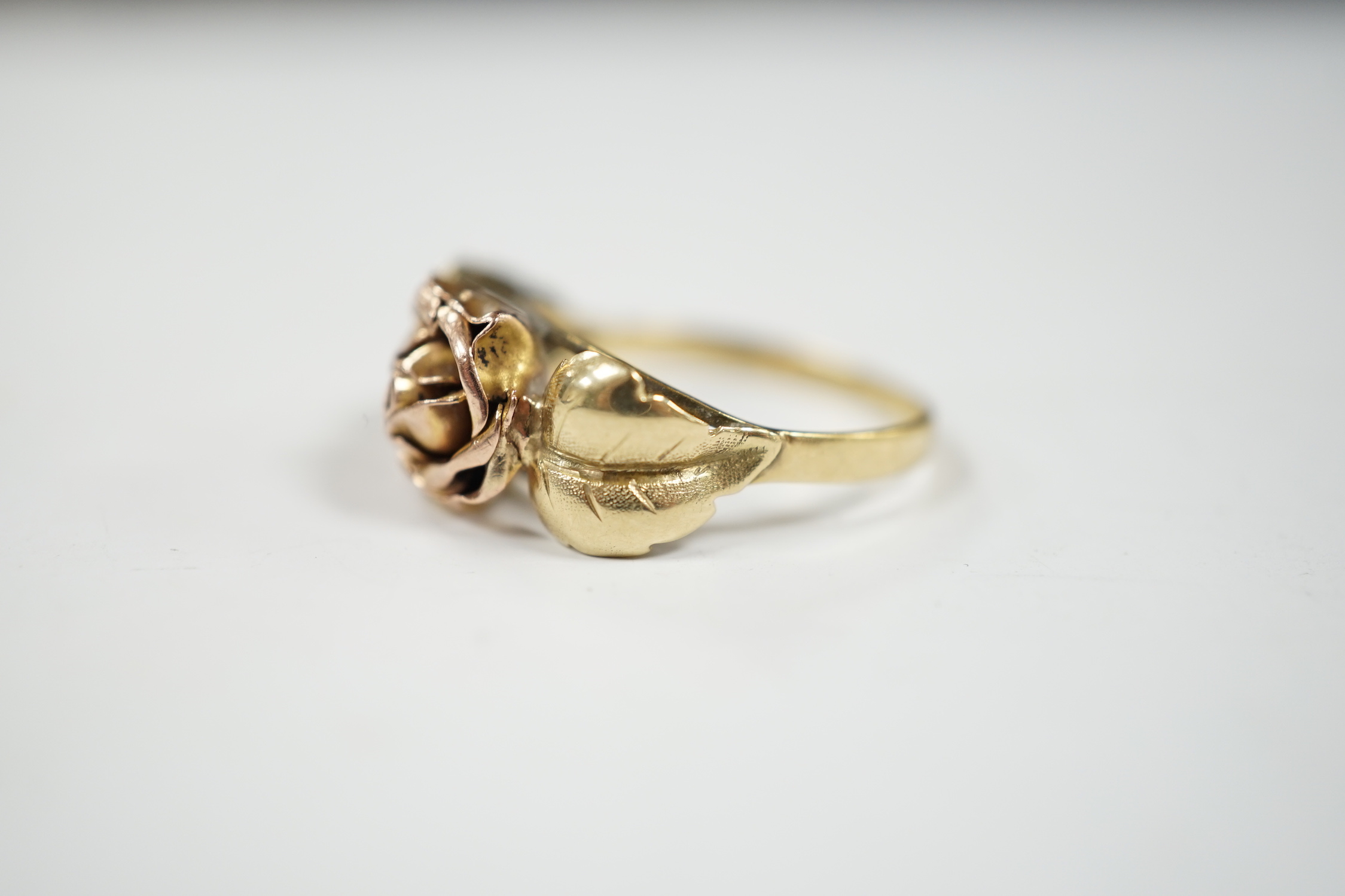 A two colour 585 flower head ring, with leaf shoulders, size P/Q, 3 grams.